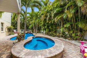 uma piscina num quintal com um círculo de madeira à volta em Carefree Cay em Anna Maria