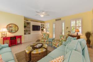 uma sala de estar com um sofá azul e cadeiras em Carefree Cay em Anna Maria