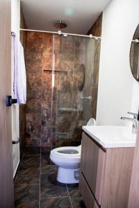 a bathroom with a toilet and a sink and a shower at Apartamento frente al CC Viva Envigado in Envigado
