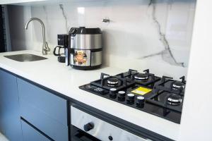 a kitchen counter with a coffee maker on a stove at Apartamento frente al CC Viva Envigado in Envigado