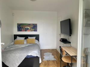 a bedroom with a bed and a flat screen tv at Chambre avec vue sur la campagne! in Saint-Clair-sur-Epte