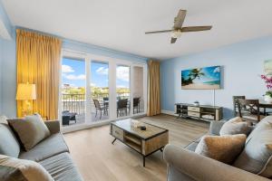 a living room with two couches and a table at Lovely Resort Low Floor Condo! Just Steps to the Beach & Restaurants! by Dolce Vita Getaways PCB in Panama City Beach