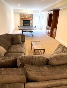 a living room with couches and a ping pong table at 5 Plus Bedroom Over Sized Colonial in Very Private Setting in Pound Ridge