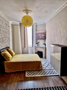 1 dormitorio con cama y lámpara de araña en T3 moderne et climatisé - Plages à pied - PARKING GRATUIT, en Vallauris