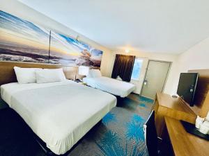 a hotel room with two beds and a flat screen tv at Days Inn by Wyndham Ardmore in Ardmore