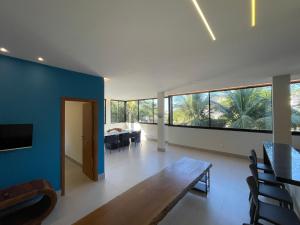 ein Esszimmer mit einem Tisch und einer blauen Wand in der Unterkunft Reserva Santa Helena in Anchieta