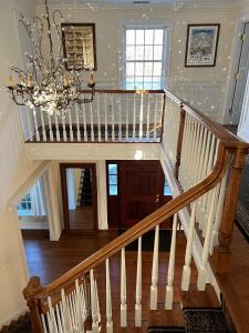 a staircase in a house with a chandelier at 5 Plus Bedroom Over Sized Colonial in Very Private Setting in Pound Ridge