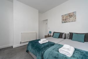 a bedroom with a large bed with towels on it at Cosy 2BR Apartment with Free Street Parking in Frodingham