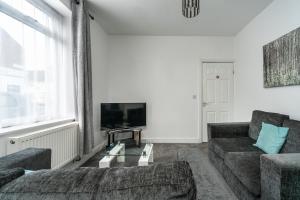 - un salon avec un canapé et une télévision dans l'établissement Cosy 2BR Apartment with Free Street Parking, à Frodingham