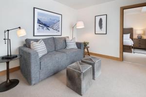 a living room with a gray couch and a bedroom at The Snowpine Lodge in Alta