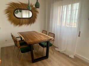 a dining room table with chairs and a mirror at Midway Apartamento in Torremolinos