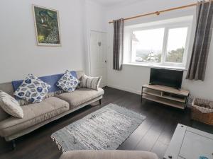 a living room with a couch and a television at Harbour Village Views in Goodwick