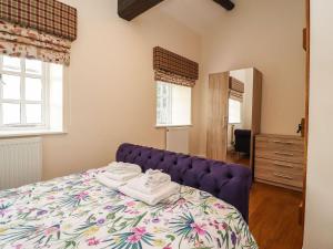 a bedroom with a purple bed with towels on it at Balloo in Lancaster