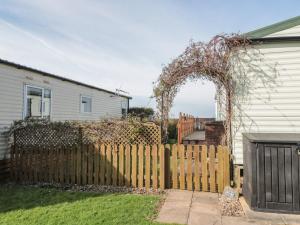 a wooden fence with an arch in front of a house at Bayview 23 in Taunton