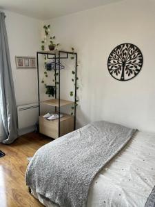 a bedroom with a bed and a shelf with plants at Chambre avec vue sur la campagne! in Saint-Clair-sur-Epte