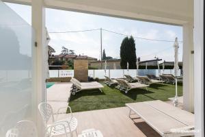 een patio met een stapel stoelen op het gras bij Hotel Villa Katy in Bardolino