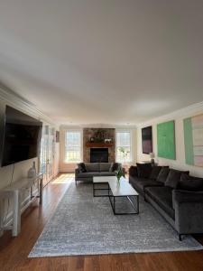 a living room with a couch and a table at 5 Plus Bedroom Over Sized Colonial in Very Private Setting in Pound Ridge