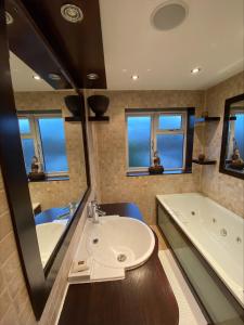 bagno con lavandino e vasca di Tranquil Twickenham Maisonette: Ideal for Couples a Londra