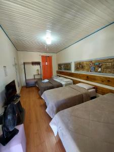 een kamer met vier bedden en een televisie. bij Pousada Inconfidência Mineira in Ouro Preto