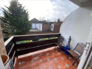 un balcone con 2 sedie e una pianta di Tranquil Twickenham Maisonette: Ideal for Couples a Londra