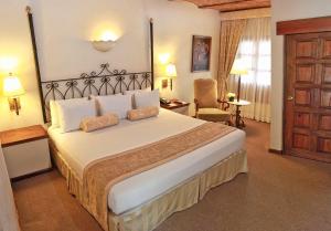 a bedroom with a large bed in a hotel room at Villa Antigua in Tequisquiapan