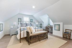 a bedroom with a large bed with a bench at Charming Beachside Home in Bridgeport