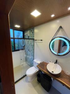 La salle de bains est pourvue de toilettes, d'un lavabo et d'un miroir. dans l'établissement Reserva Santa Helena, à Anchieta