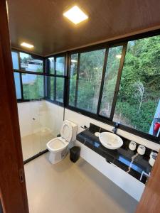 a bathroom with a toilet and a sink at Reserva Santa Helena in Anchieta