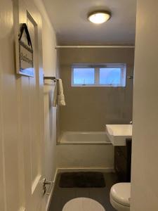 La salle de bains blanche est pourvue de toilettes et d'un lavabo. dans l'établissement Camden town Entire flat 3 min from station, à Londres