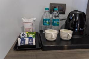 a counter with two bottles of water and a coffee maker at Bali guest house in Srinagar