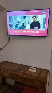 Elle comprend une télévision à écran plat murale et une table en bois. dans l'établissement 2 ambientes equipado para 4 personas centro de mar del plata, à Mar del Plata