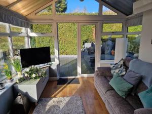 a living room with a couch and a tv at Cribden Hill View in Rawtenstall