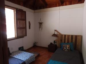 um quarto com uma cama e uma janela em Casa Qi Boho B&B em Cabuya