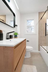 Baño blanco con lavabo y aseo en New Paltz Zen Wellness Cabin w/ Hot Tub, en New Paltz