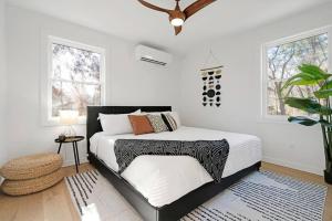 1 dormitorio con 1 cama con paredes y ventanas blancas en New Paltz Zen Wellness Cabin w/ Hot Tub, en New Paltz