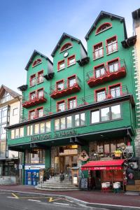 a large green building on the corner of a street at Hotel Aran La Abuela in Vielha