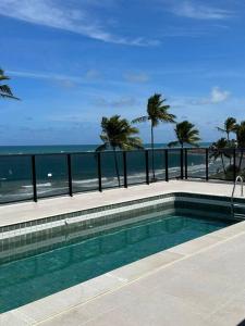 Flat Beira Mar Porto de Galinhas - Pé na areia في بورتو دي غالينهاس: حمام سباحة مع إطلالة على الشاطئ