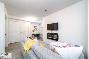 a living room with a blue couch and a tv at *Vibrant Suite* Long Stays - Wi-Fi - Fireplace - NFLX in Edmonton