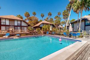 a swimming pool with chairs and a house at Peaceful River Bungalow in Crystal River