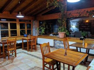 a restaurant with wooden tables and chairs and a bar at Hotel Rural El Rexacu in Bobia de Arriba