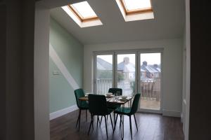 a dining room with a table and chairs and windows at Contractors, Professionals & Relocators Dream in Leicester