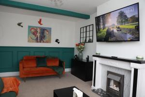 sala de estar con chimenea y TV de pantalla plana en Contractors, Professionals & Relocators Dream, en Leicester