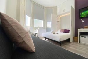 ein Schlafzimmer mit einem Bett und einem TV in der Unterkunft Apt 04 Seaside Serenity Chic Studio Steps to Promenade in Brighton & Hove