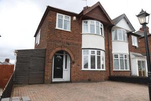 a brick house with a white door on a brick driveway at Contractors, Professionals & Relocators Dream in Leicester