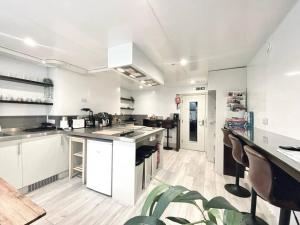 a large kitchen with white cabinets and counters at Apt 04 Seaside Serenity Chic Studio Steps to Promenade in Brighton & Hove