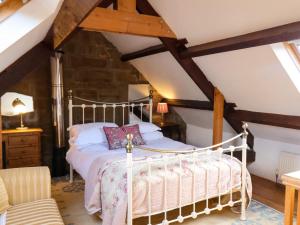 una camera da letto con letto bianco in mansarda di Daffodil Cottage a Danby