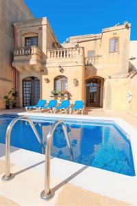 una casa con piscina di fronte a una casa di Villa Harruba a Xagħra