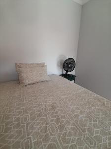 a bedroom with a bed with a pillow on it at Quarto para temporada in Ribeirão Preto