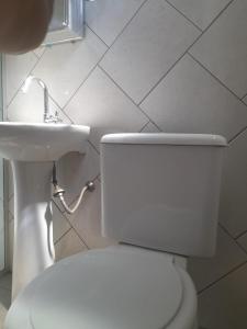 Łazienka z białą toaletą i umywalką w obiekcie Quarto para temporada w mieście Ribeirão Preto