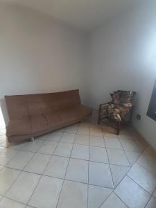 a living room with a couch and a side table at Quarto para temporada in Ribeirão Preto